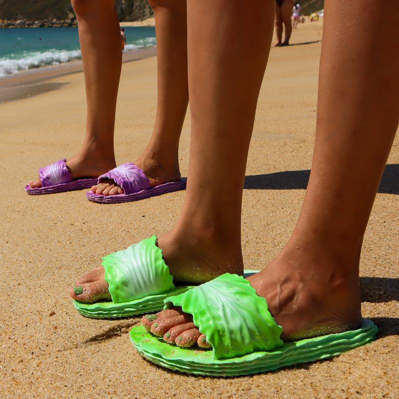 Two people wearing Coddies Cabbage Creepers on the beach, one green and one purple